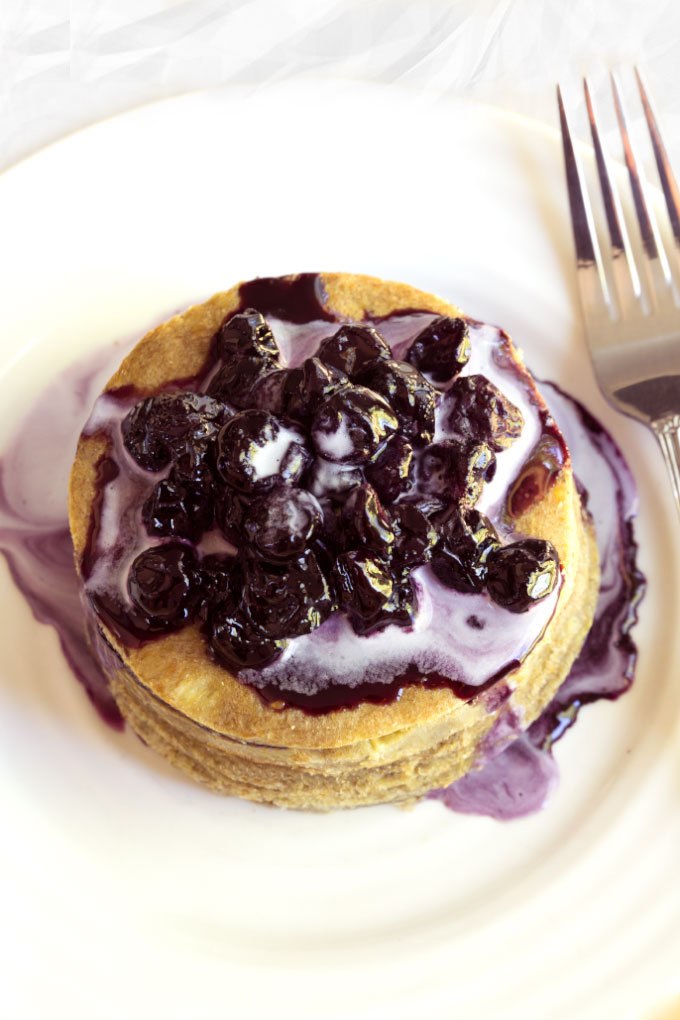 raw pancakes with blueberry sauce and whipped cream