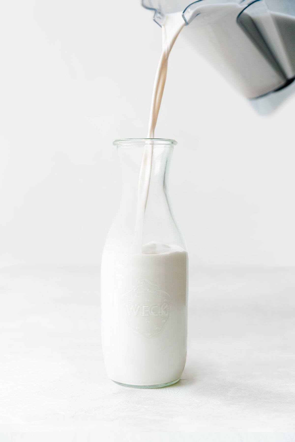 pouring almond milk from a Vitamix blender